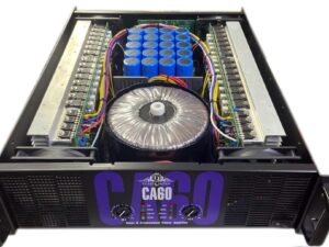 Inside view of the Ejimek Japan CA60 professional power amplifier showcasing its high-capacity toroidal transformer, large blue filter capacitors, dual heat sinks, and robust internal wiring. Engineered for reliable, high-power audio output with advanced thermal management and component layout.