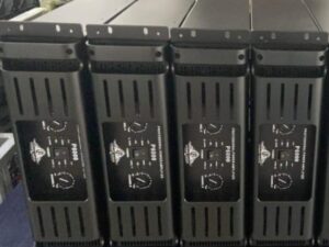 Four black professional power amplifiers labeled P8000 from Ejimek Japan placed vertically side by side. Each amplifier has two control knobs for channels A and B, power switches, and LED indicators on the front panels. The units have ventilation slots on the sides and are positioned closely together on a table or shelf.