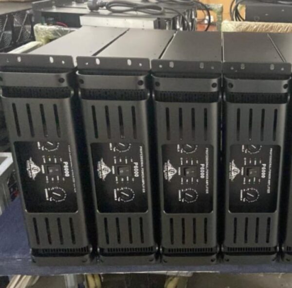 Four black professional power amplifiers labeled P8000 from Ejimek Japan placed vertically side by side. Each amplifier has two control knobs for channels A and B, power switches, and LED indicators on the front panels. The units have ventilation slots on the sides and are positioned closely together on a table or shelf.