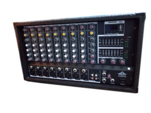 Front view of the Ejimek Japan PC-10800USB powered audio mixer, featuring 10 channels with XLR and line inputs, built-in graphic equalizer, USB/SD card playback module, rotary knobs for EQ and gain control, and dedicated AUX and phantom power controls. Enclosed in a rugged, carpeted casing suitable for stage and portable setups.